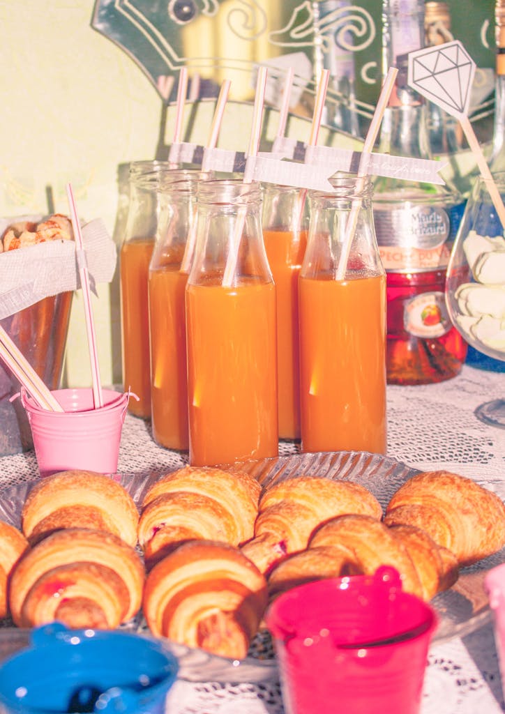 Juice in Bottles and Croissants on Table